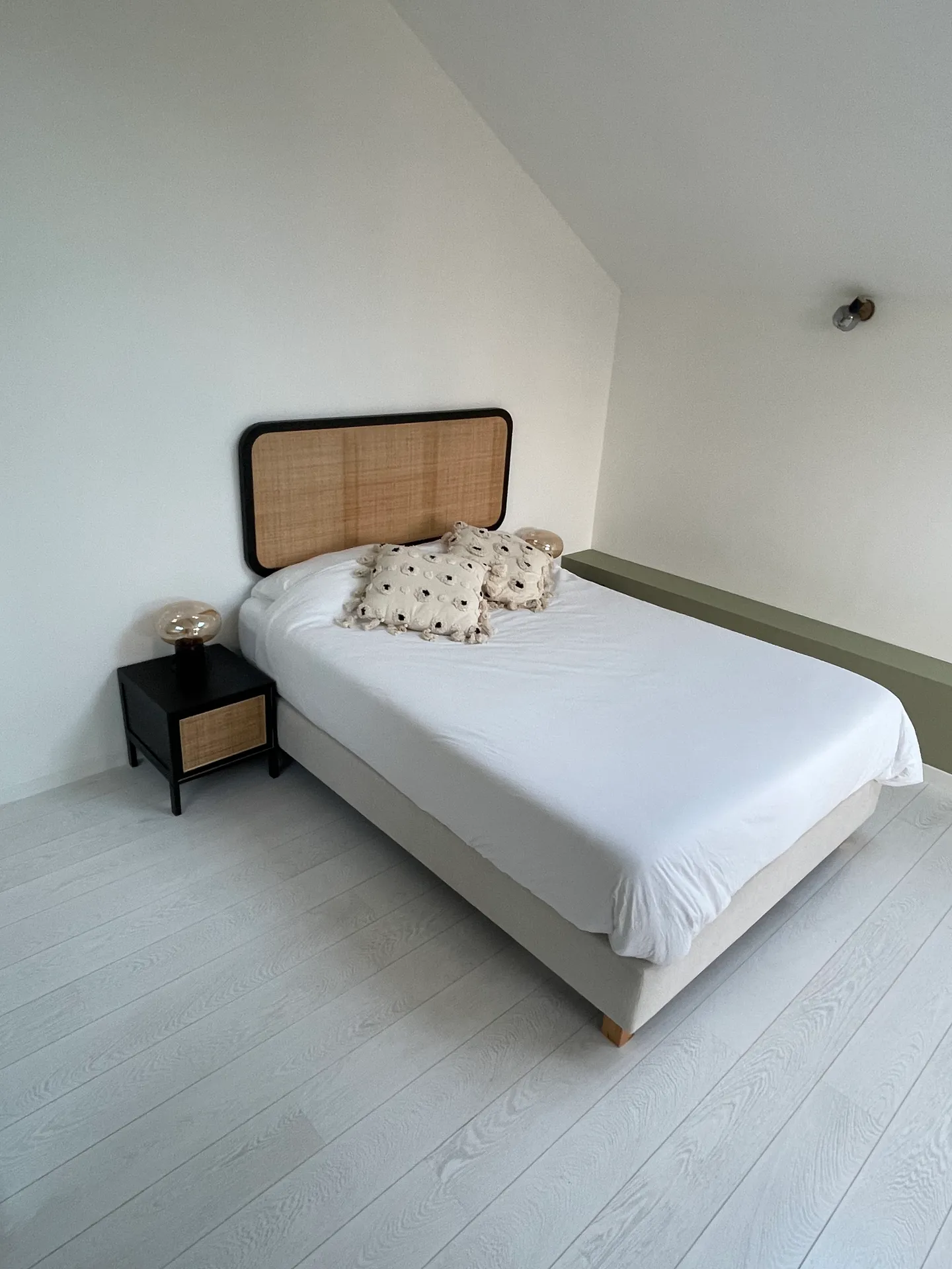 Room 4 — the double bed and its cane headboard